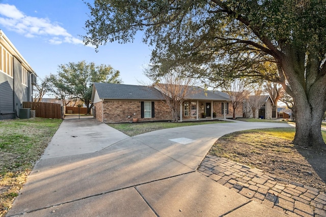 ranch-style home with central AC unit and a front yard