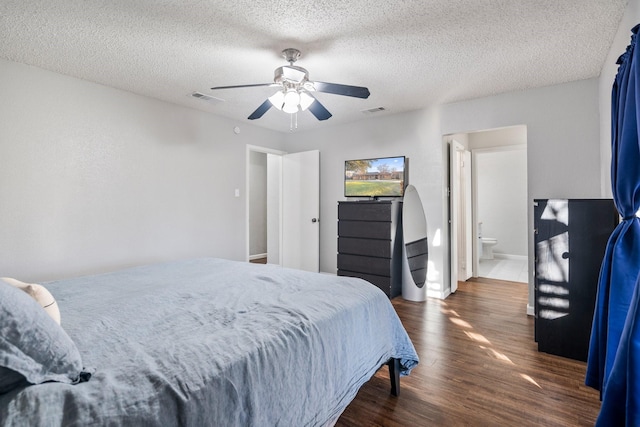 bedroom with connected bathroom, a textured ceiling, dark wood-type flooring, and ceiling fan