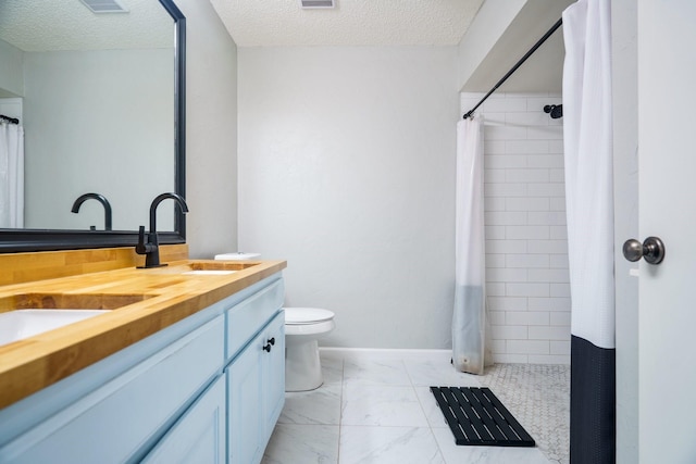 bathroom with vanity, curtained shower, and a textured ceiling