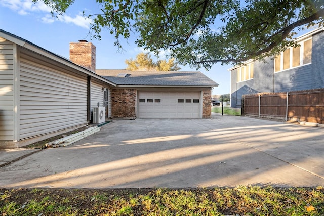 view of side of home with a garage and ac unit