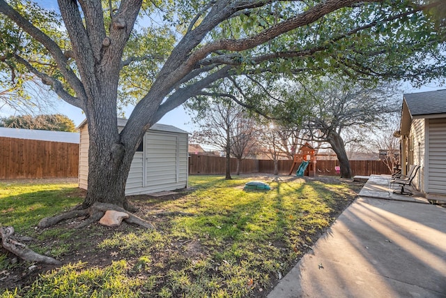 view of yard featuring a shed, a patio area, and a playground