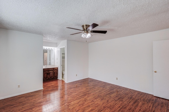 unfurnished room with sink, hardwood / wood-style floors, a textured ceiling, and ceiling fan