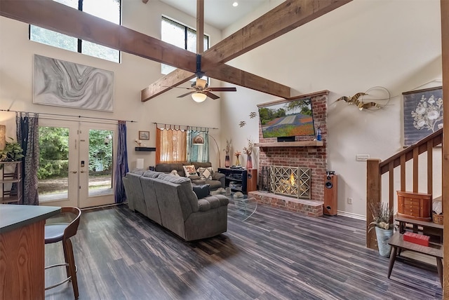 living room with dark hardwood / wood-style floors, beam ceiling, a brick fireplace, and a wealth of natural light