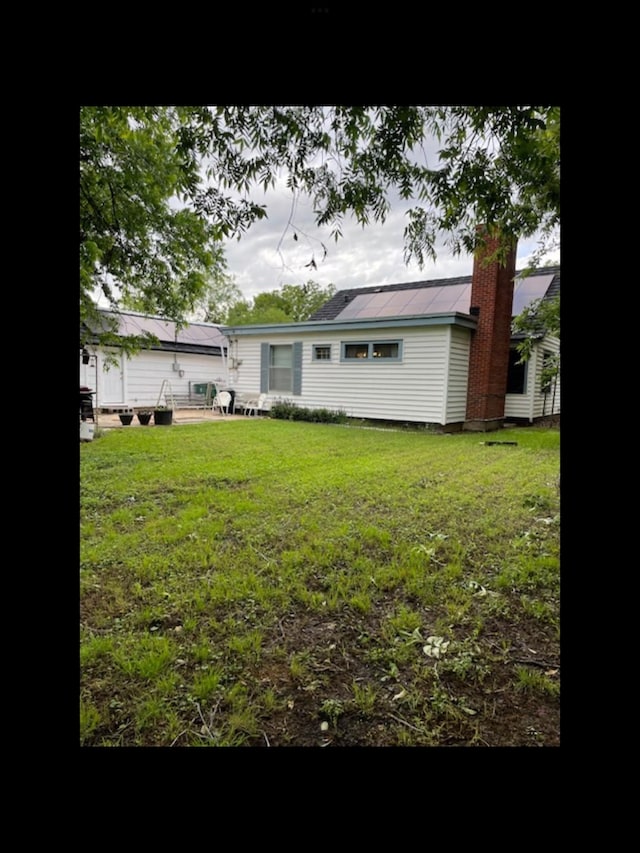 back of house featuring a lawn