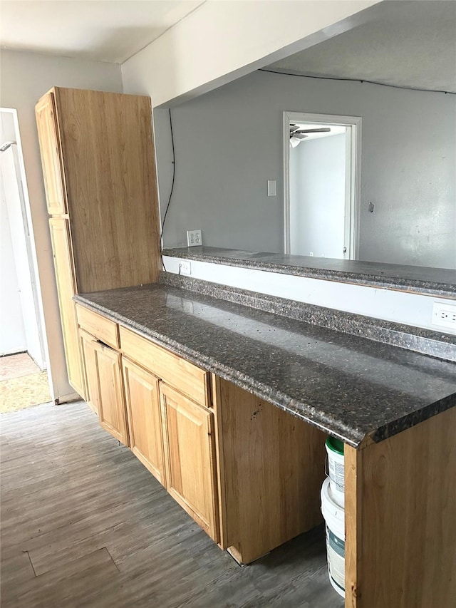 kitchen featuring dark stone countertops and dark hardwood / wood-style flooring