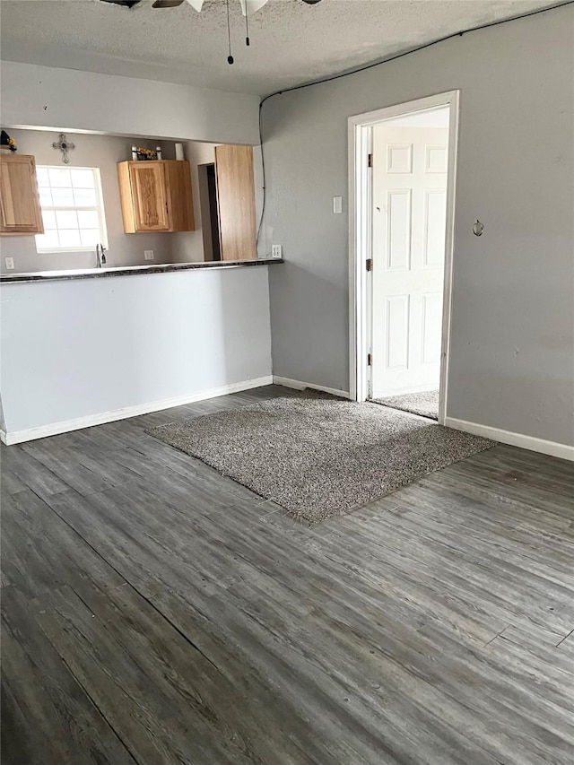 interior space with sink, a textured ceiling, dark wood-type flooring, and ceiling fan