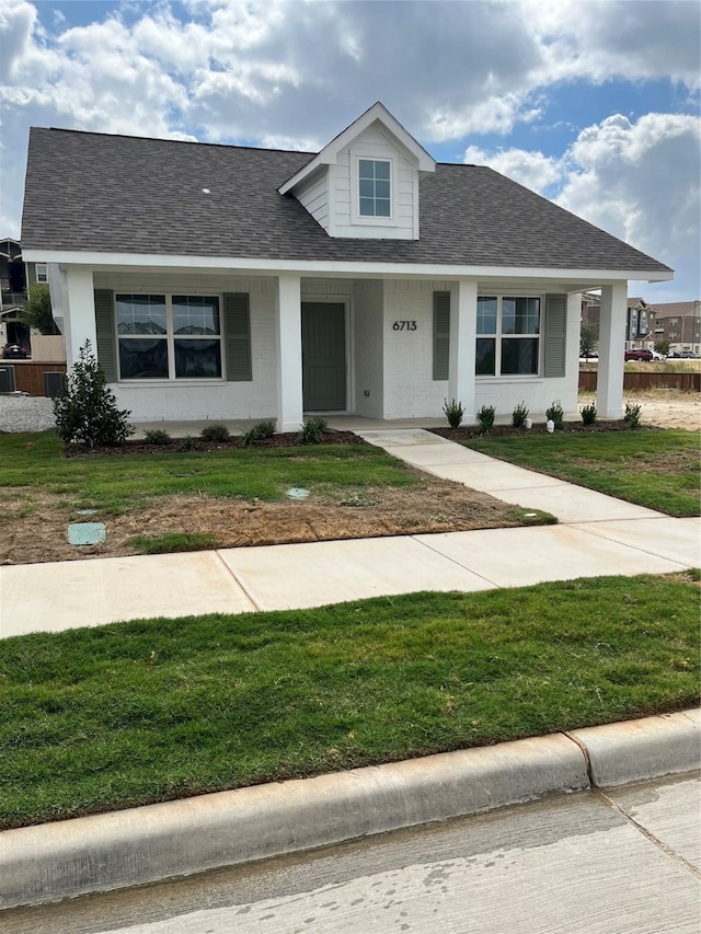 view of front facade featuring covered porch and a front yard