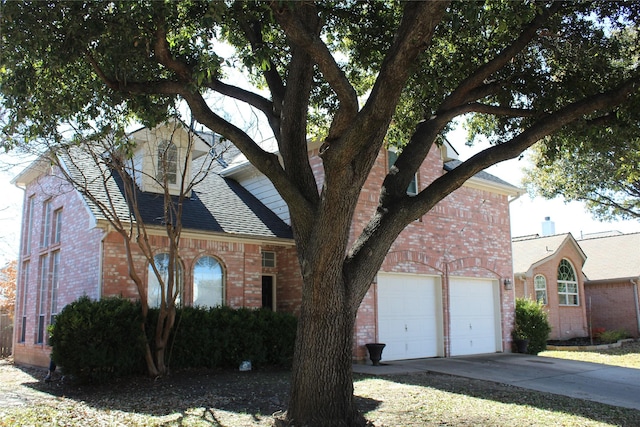 view of front of house featuring driveway, brick siding, roof with shingles, and an attached garage