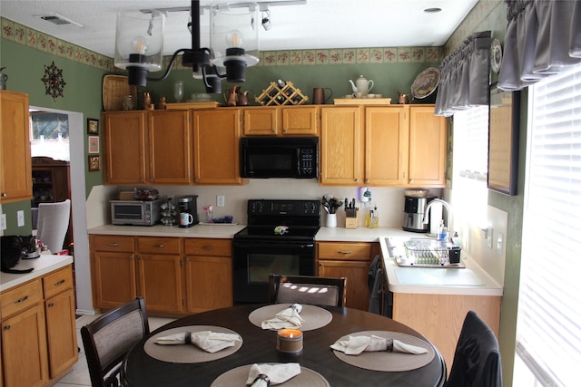 kitchen with a notable chandelier, plenty of natural light, and black appliances