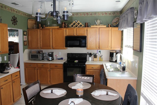 kitchen with a notable chandelier and black appliances