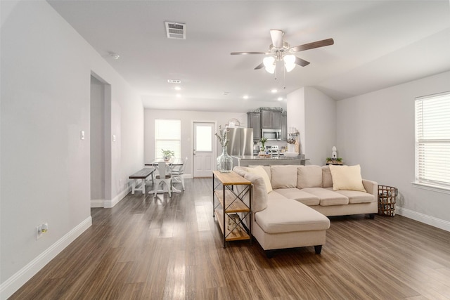 living room featuring lofted ceiling, dark wood-type flooring, and ceiling fan