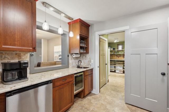 kitchen with sink, light stone counters, decorative light fixtures, stainless steel dishwasher, and beverage cooler