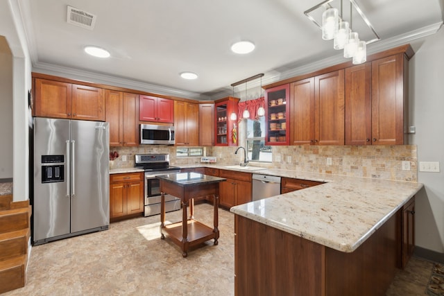 kitchen with crown molding, appliances with stainless steel finishes, decorative light fixtures, and kitchen peninsula