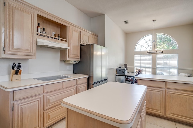 kitchen featuring light brown cabinetry, a center island, black electric cooktop, stainless steel refrigerator, and pendant lighting