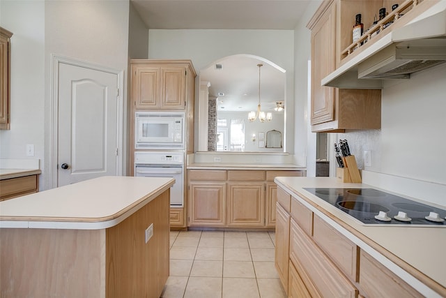 kitchen featuring pendant lighting, white appliances, light brown cabinetry, and a center island