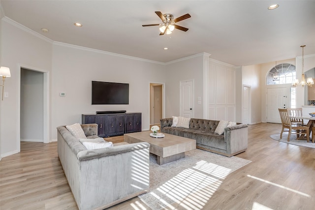 living room featuring ornamental molding, ceiling fan with notable chandelier, and light hardwood / wood-style flooring