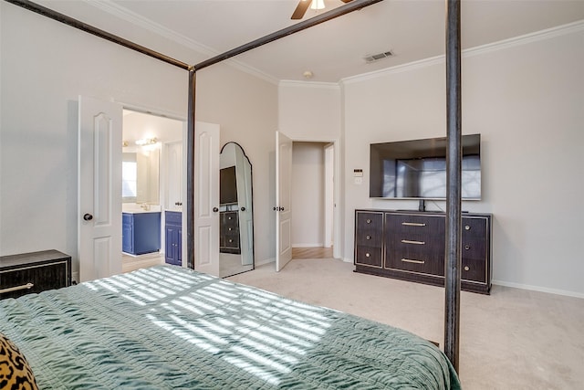 bedroom featuring ceiling fan, light colored carpet, ornamental molding, and ensuite bathroom