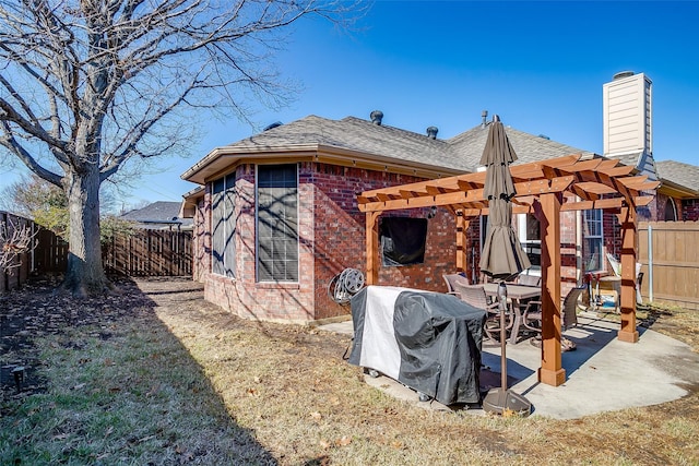 back of property featuring a yard, a pergola, and a patio area