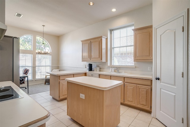 kitchen with sink, hanging light fixtures, a kitchen island, light brown cabinetry, and kitchen peninsula