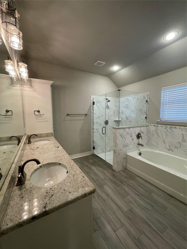 bathroom with lofted ceiling, vanity, and separate shower and tub