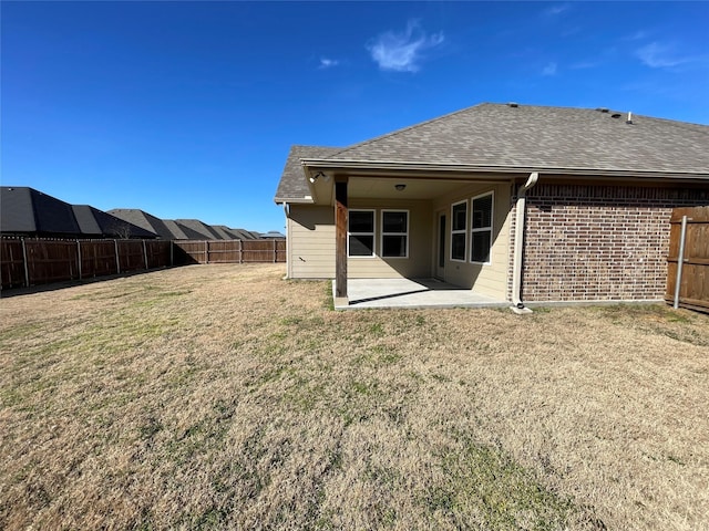 back of house with a yard and a patio