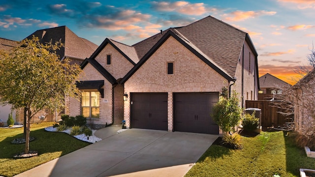 view of front of home with a garage and a lawn