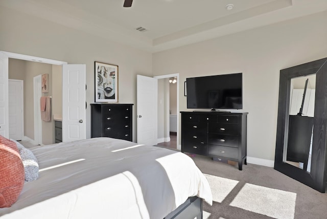 carpeted bedroom with a tray ceiling and ceiling fan