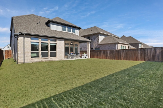 rear view of house featuring a yard, a patio, and ceiling fan