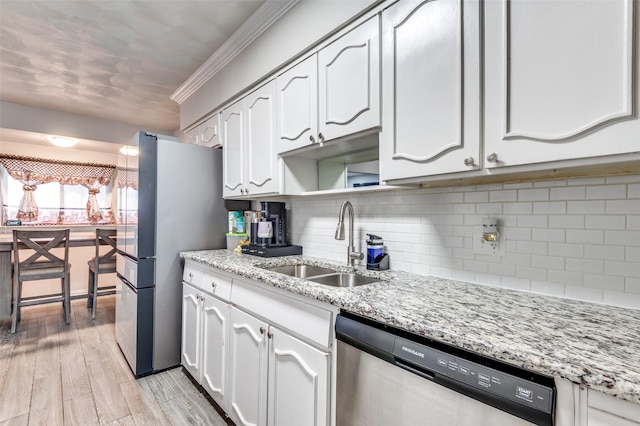 kitchen featuring tasteful backsplash, sink, white cabinets, stainless steel appliances, and light stone countertops