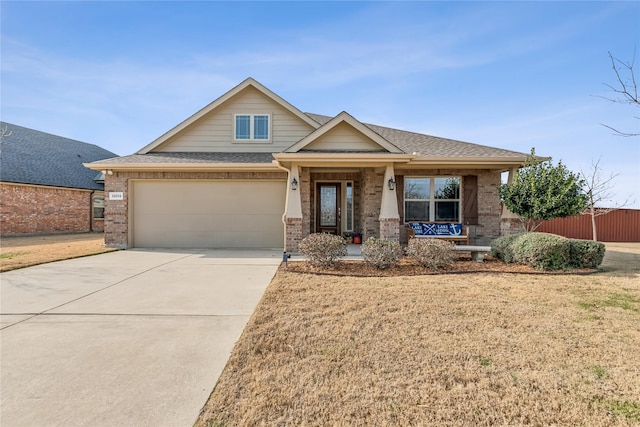 craftsman house with a garage, covered porch, and a front lawn