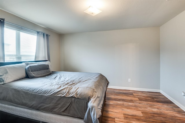 bedroom with dark wood-type flooring