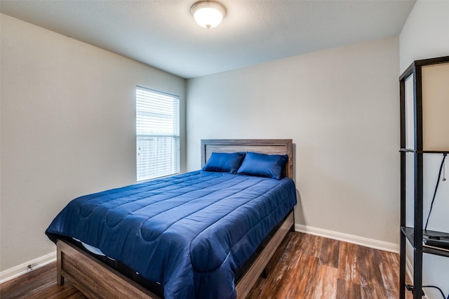 bedroom with dark hardwood / wood-style floors