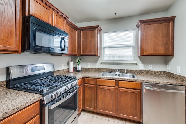 kitchen with appliances with stainless steel finishes, sink, and light tile patterned floors