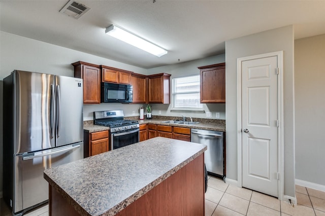 kitchen featuring sink, a kitchen island, light tile patterned flooring, and appliances with stainless steel finishes