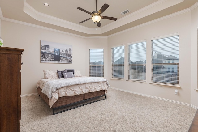 bedroom featuring crown molding, a tray ceiling, ceiling fan, and carpet flooring