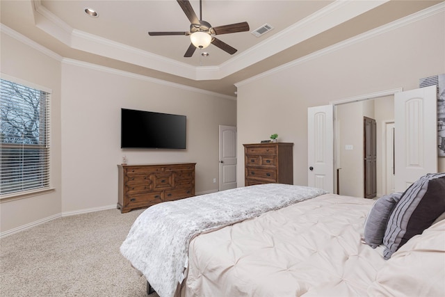 carpeted bedroom featuring ceiling fan, ornamental molding, and a raised ceiling