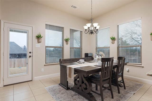 tiled dining space with a chandelier