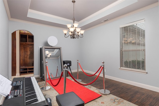 interior space featuring a raised ceiling, crown molding, an inviting chandelier, and dark hardwood / wood-style flooring