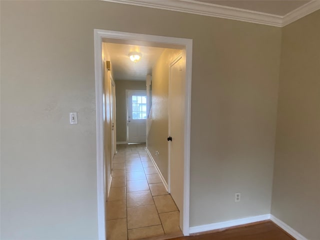 hall featuring crown molding and light tile patterned flooring