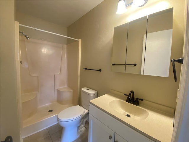 bathroom featuring walk in shower, vanity, toilet, and tile patterned flooring