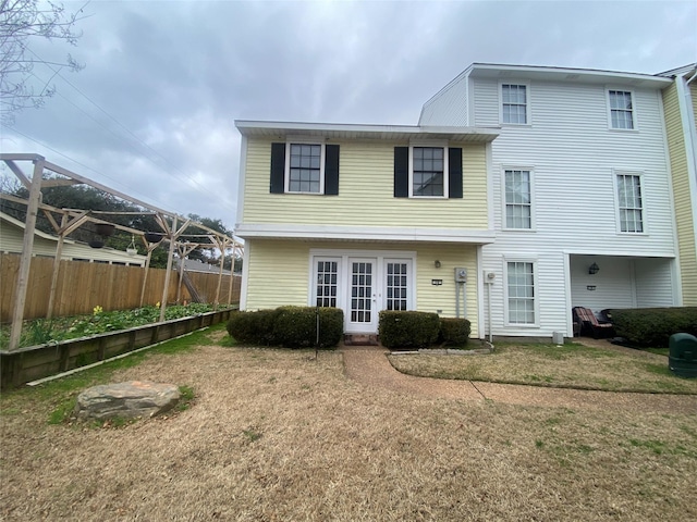 back of house featuring a yard and french doors