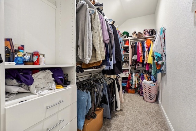 walk in closet with vaulted ceiling and carpet floors