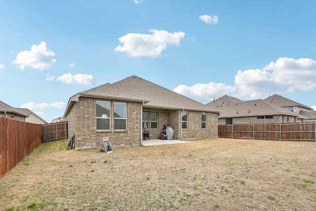 back of house featuring a patio and a yard