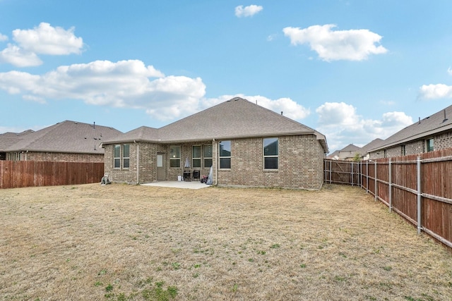 back of property with a patio and a lawn