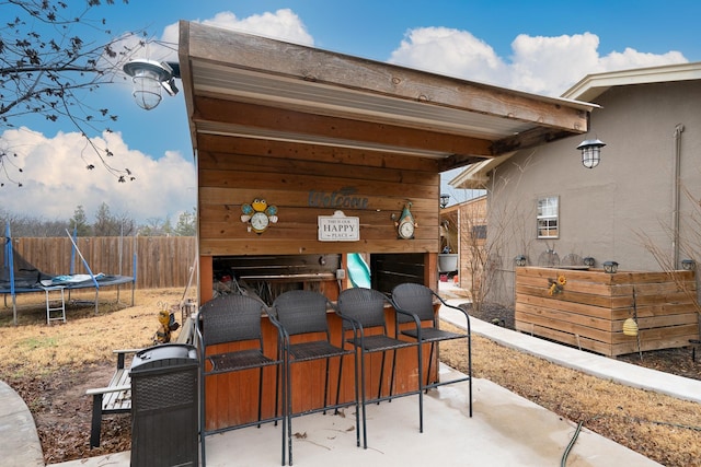 view of patio featuring exterior bar and a trampoline