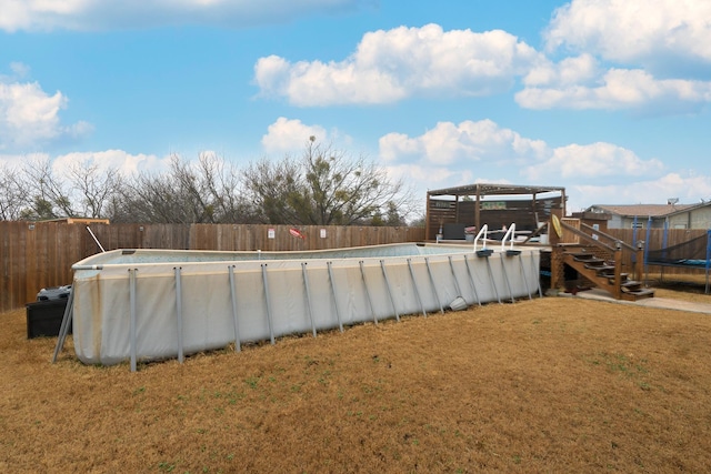 view of yard featuring a fenced in pool, a gazebo, and a trampoline