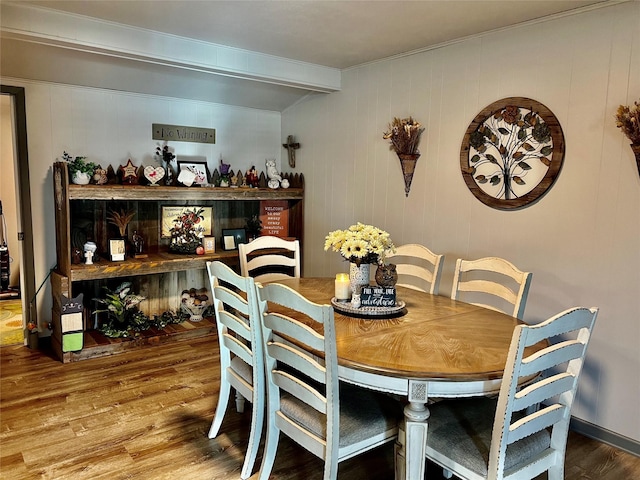 dining room featuring beam ceiling and hardwood / wood-style flooring