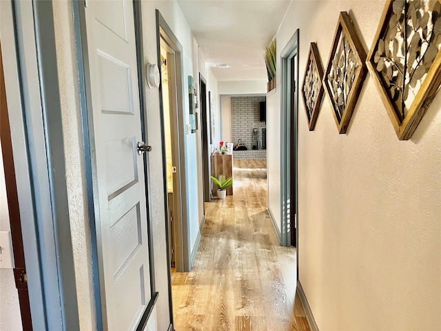 corridor with light hardwood / wood-style floors