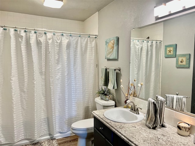 full bathroom with vanity, hardwood / wood-style floors, shower / bath combo, and toilet