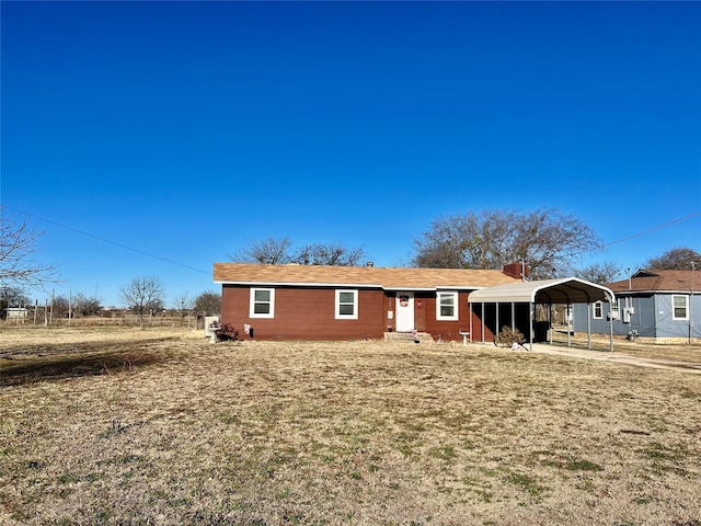 view of front of property featuring a front yard and a carport